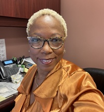 The image features a woman with braided hair and a radiant smile, wearing professional attire. Her confident demeanor symbolizes her role as an advocate for education and equity in higher education. The image likely represents Paula Roberson, Ed.D., a leader dedicated to social justice initiatives at Hudson County Community College.