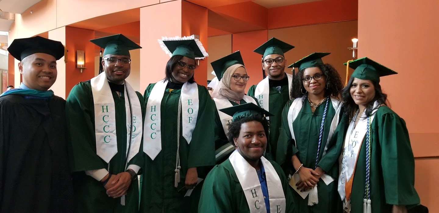 This is an image of 8 students in green cap and gowns at their graduation