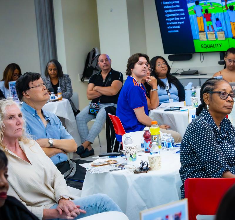 Participants engage in a professional development session at HCCC, examining concepts of equality and equity through discussion and interactive learning.