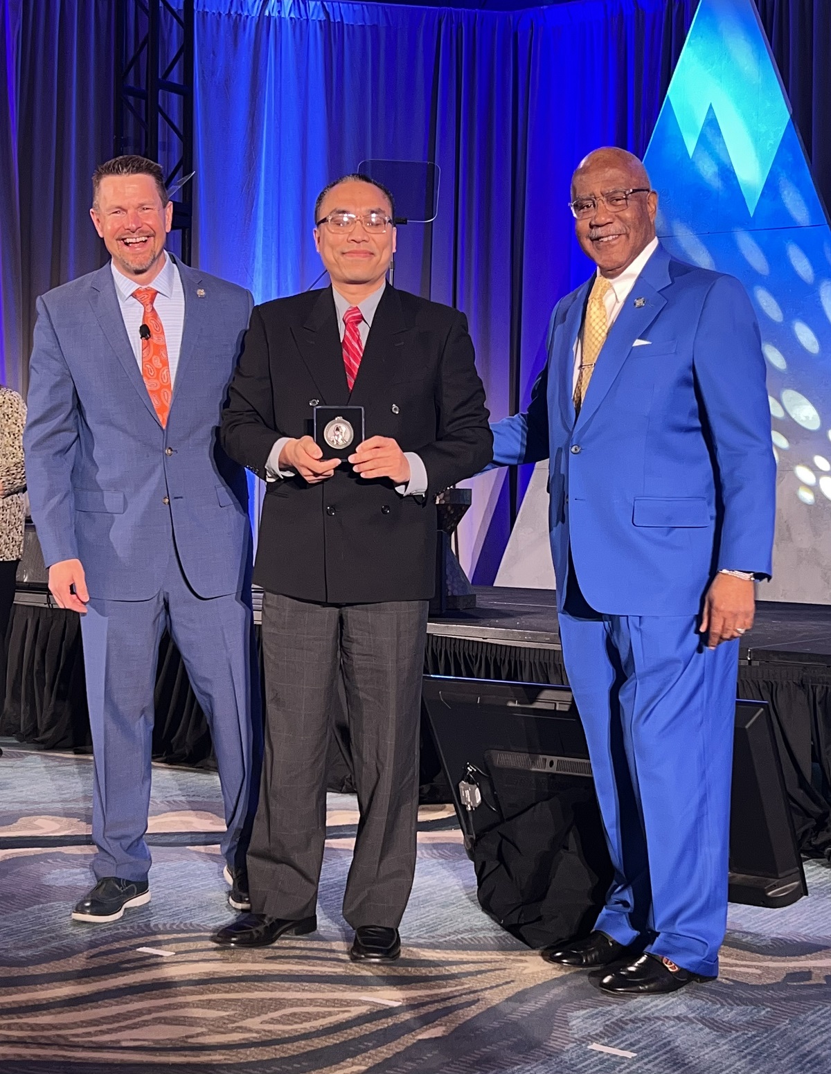 Hudson County Community College Instructor of Engineering Science Dr. Clive Li (center) is a recipient of the American Association of Community Colleges’ (AACC) 2023 Dale P. Parnell Distinguished Faculty Award. Pictured with Dr. Li is AACC Board of Directors Chair, Dr. Joseph Schaffer (left), and AACC President and CEO, Dr. Walter G. Bumphus.