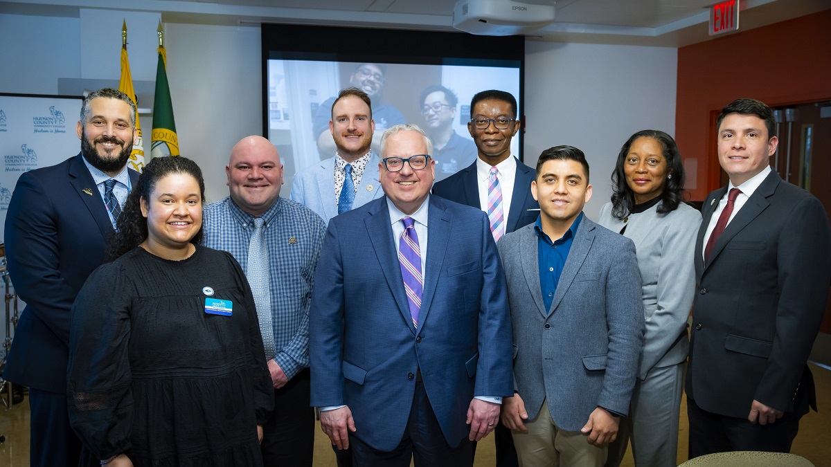 Pictured with HCCC President, Dr. Christopher Reber (center), are, from left, Vice President for Diversity, Equity and Inclusion, Yeurys Pujols; Assistant Director of the North Hudson Campus, Diana Galvez; Tutor, Carlos R. Dunn-Fernández; alumnus, Warren Rigby; Assistant Professor, Lester McRae; alumnus, Bladimir Quito; Lecturer, Sharon Daughtry; and alumnus, Cesar Orozco.