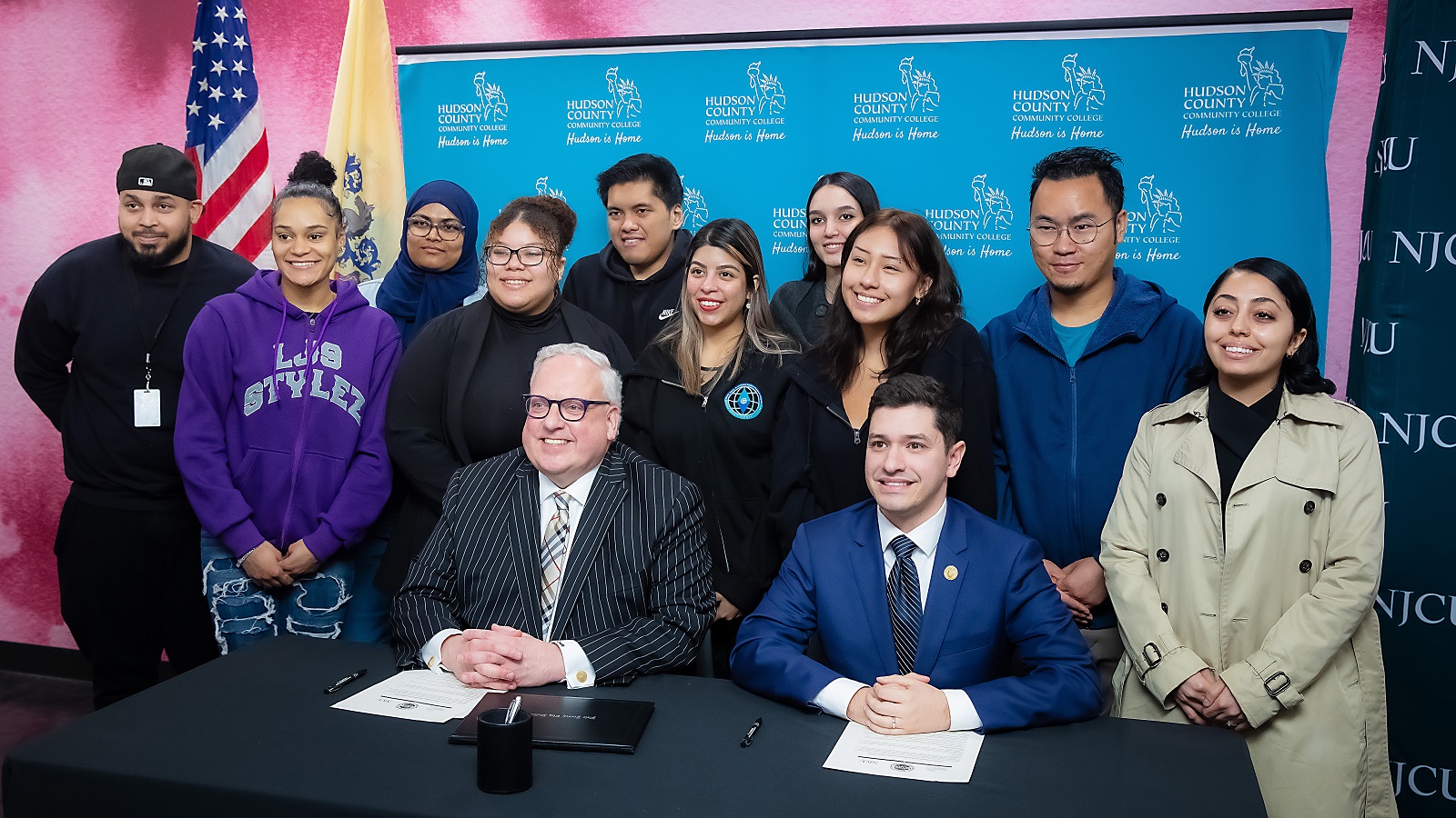 HCCC President Dr. Christopher Reber and NJCU President Andrés Acebo sign the HCCC|NJCU CONNECT Transfer Agreement, accompanied by students who will take part in the program.