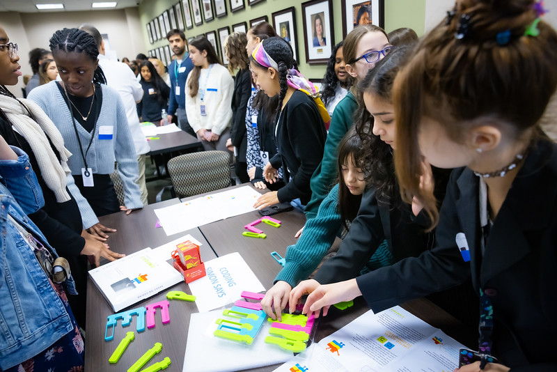 Los asistentes de Girls in Technology participan en una actividad de "Codificación: Simon Says - Hands on Coding" dirigida por latinos en STEM.